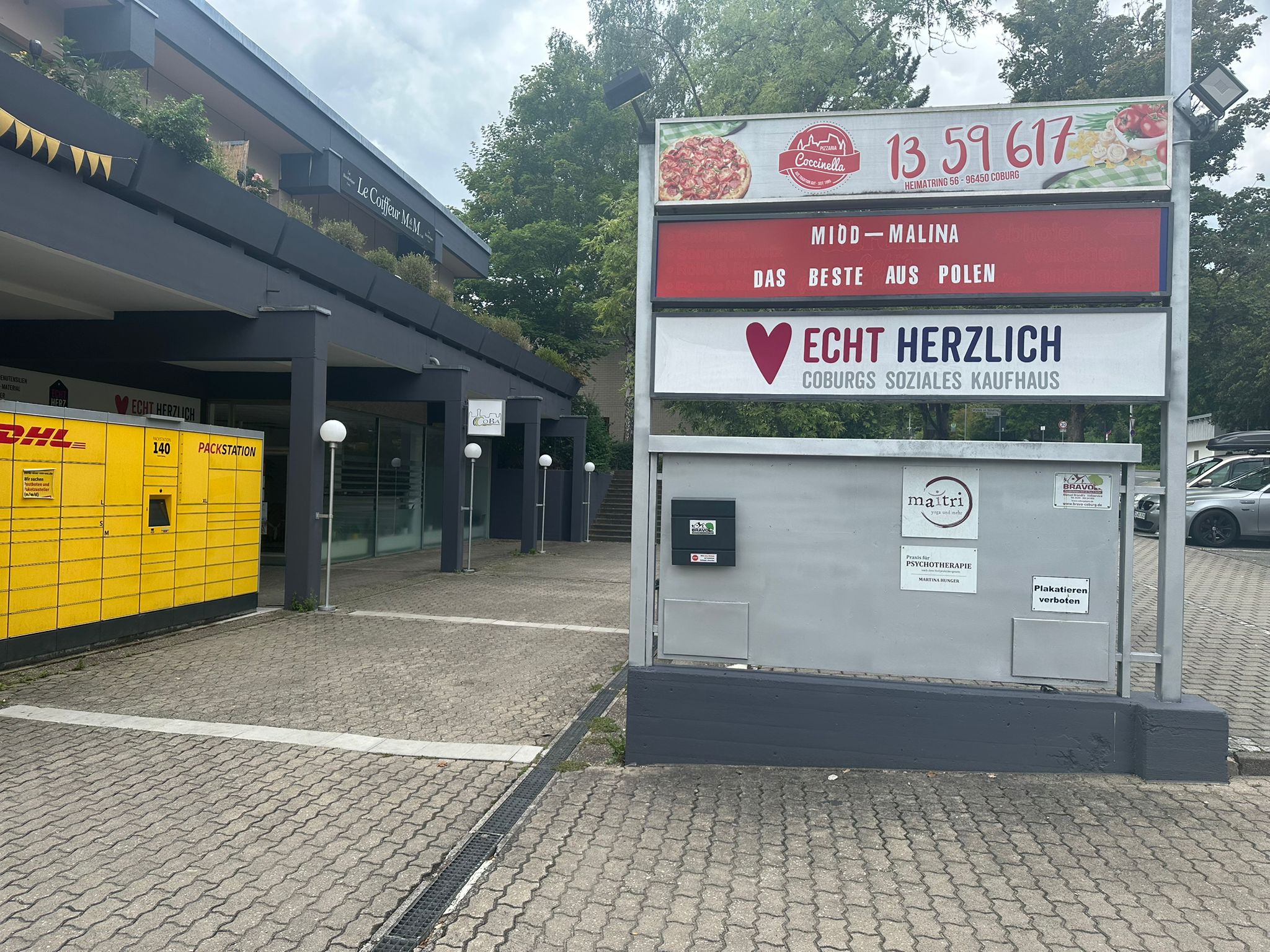 Werbetafel Seite 1 – Hofansicht Werbetafel mit Werbung der ansässigen Geschäfte im Innenhof – Seite 1