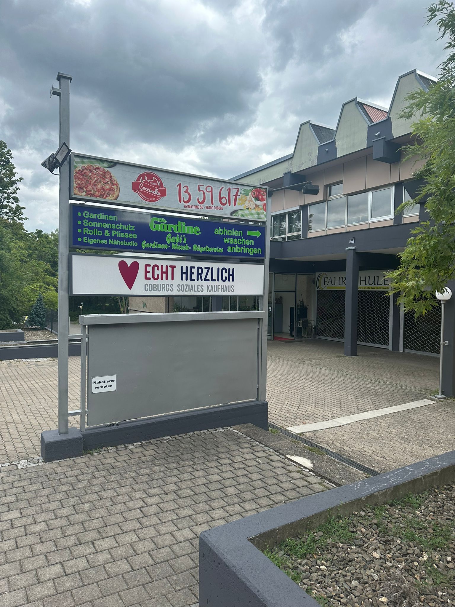 Werbetafel Seite 2 – Hofansicht Werbetafel mit Werbung der ansässigen Geschäfte im Innenhof – Seite 2